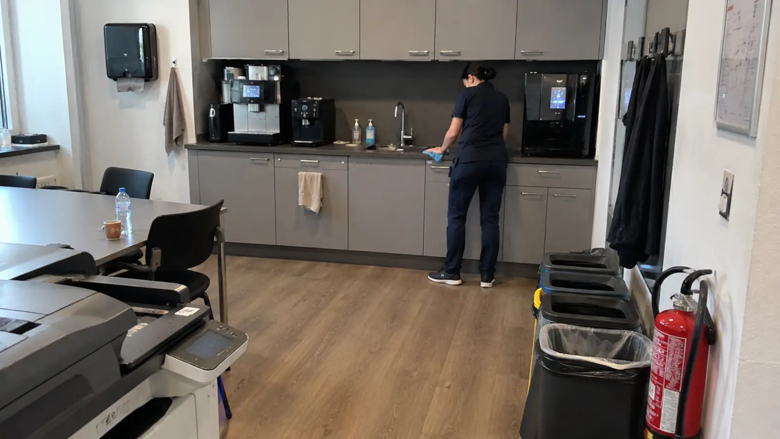 Reinigungskraft reinigt Büroküche und Kaffeebereich in einem Bürogebäude in Rostock